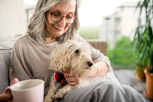 Mulher idosa com cachorro no colo