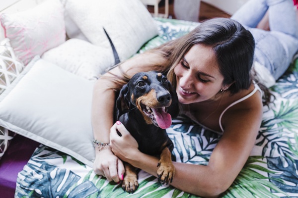 Cachorro feliz ao lado da tutora.