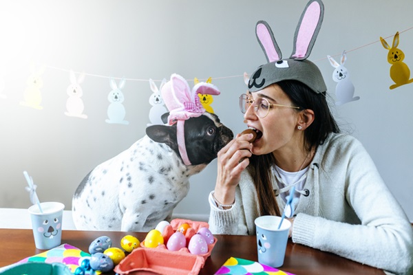 Mulher e cachorro fazendo ovos de Páscoa.