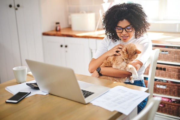 Mulher e gato tendo teleorientação veterinária.